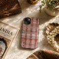 Phone case with architectural design on a marble surface with decorative items
