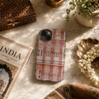 Phone case with architectural design on a marble surface with decorative items